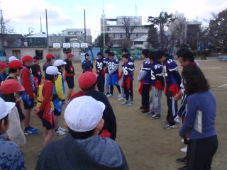 三郷小学校の児童が選手の話を立って聞いている様子を写した写真