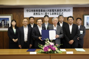 守口市教育委員会と大阪電気通信大学との調印式に出席した9名の記念撮影写真