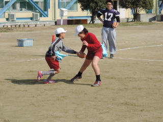 2人の下島小学校の児童がプレーしているのを選手が指導しているところを写した写真