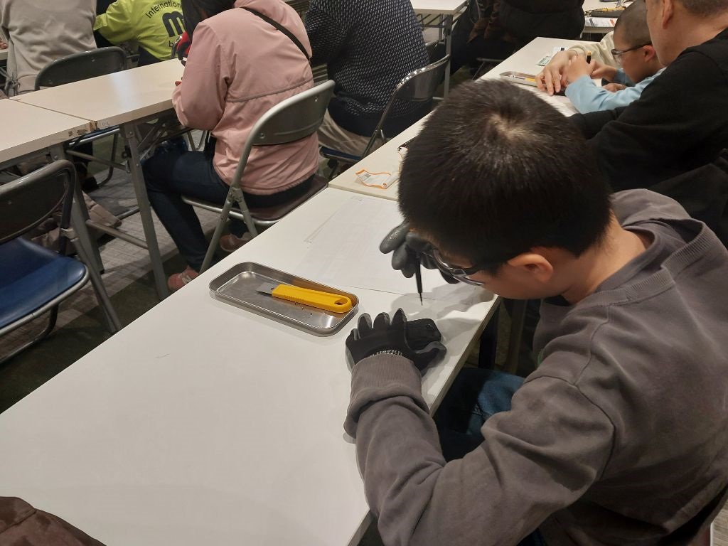 以前のケータイ分解教室の様子(男性が分解している写真)