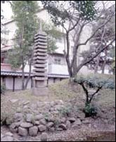 庭の中央に立っている石造十三重塔の写真