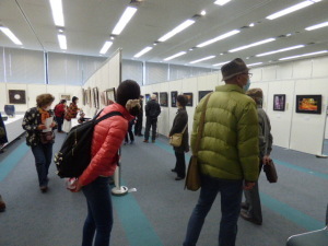 パネルに展示された絵を観ている人達の写真