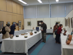 部屋に展示されたいろいろな作品を見ている来場者の人達の写真
