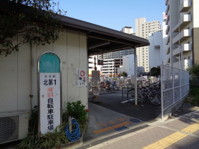 出入口に向かって左に大日駅北第1有料自転車駐車場と書かれた看板が立っている、大日駅北第1自転車駐車場も正面斜め左から写した写真