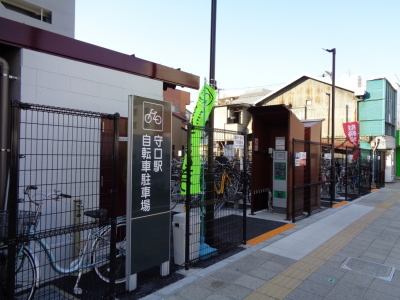 左側に守口駅自転車駐車場と書かれた看板が立っている、守口駅自転車駐車場を正面に向かって斜め左から写した写真