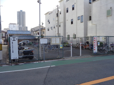 駐車場の敷地が緑色のフェンスで囲まれポールが立っている守口駅竜田通自転車駐車場の写真