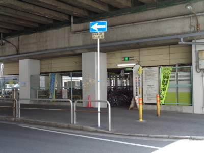 中央に標識、左側にガードレール、右側にポールが写っている守口市駅西自転車駐車場の入り口の写真
