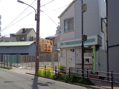 左側にスーパー玉手の黄色い看板が見え、その右に緑色で滝井・千林駅自転車駐車場事務所と書かれた滝井・千林駅自転車駐車場の写真