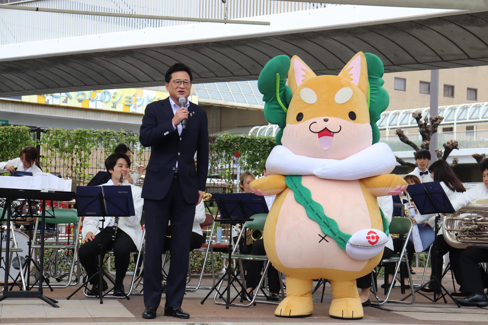 市長ともり吉がステージ上に並んでいる