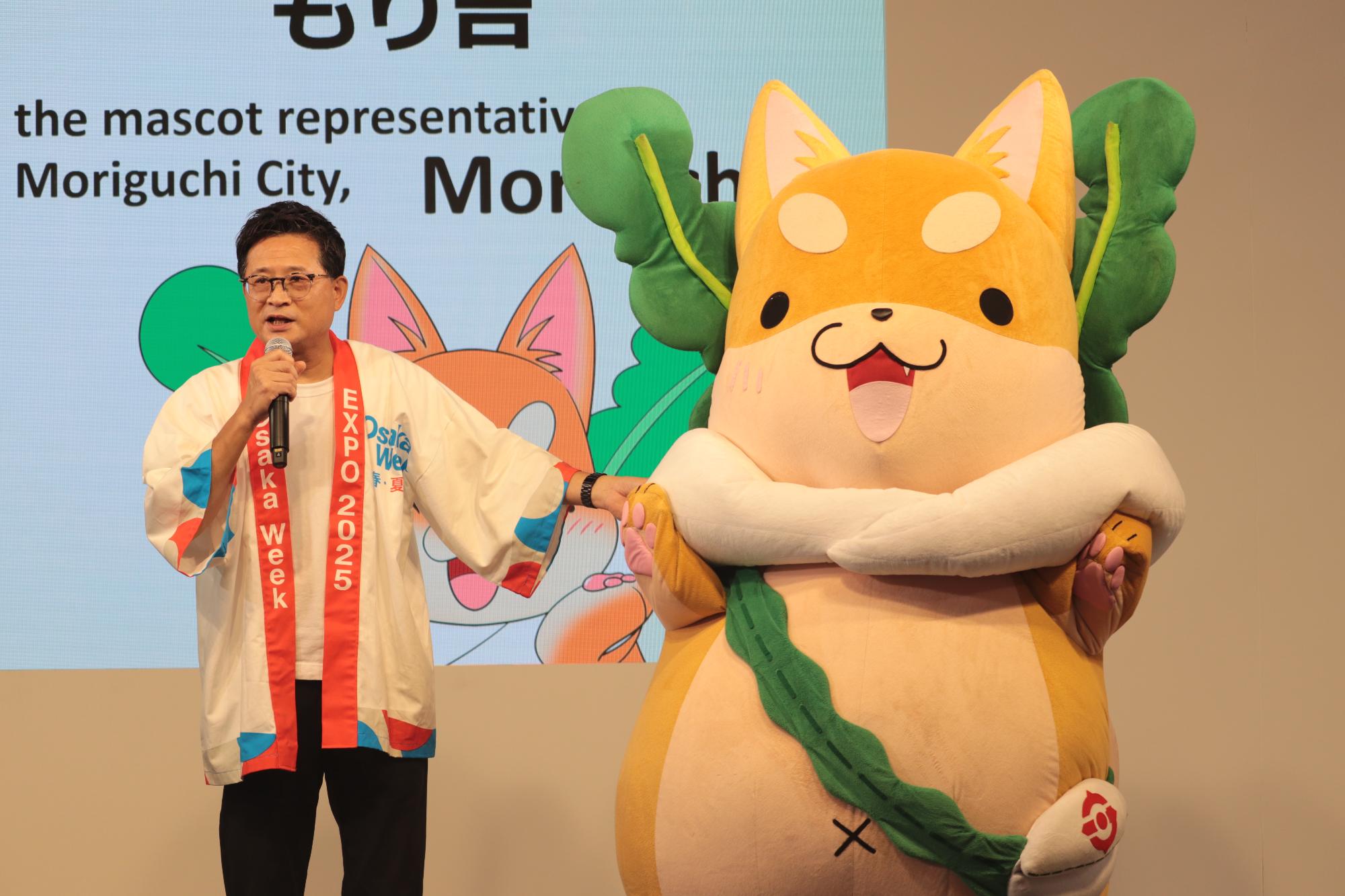 大阪関西万博にて市長ともり吉が舞台に立っています