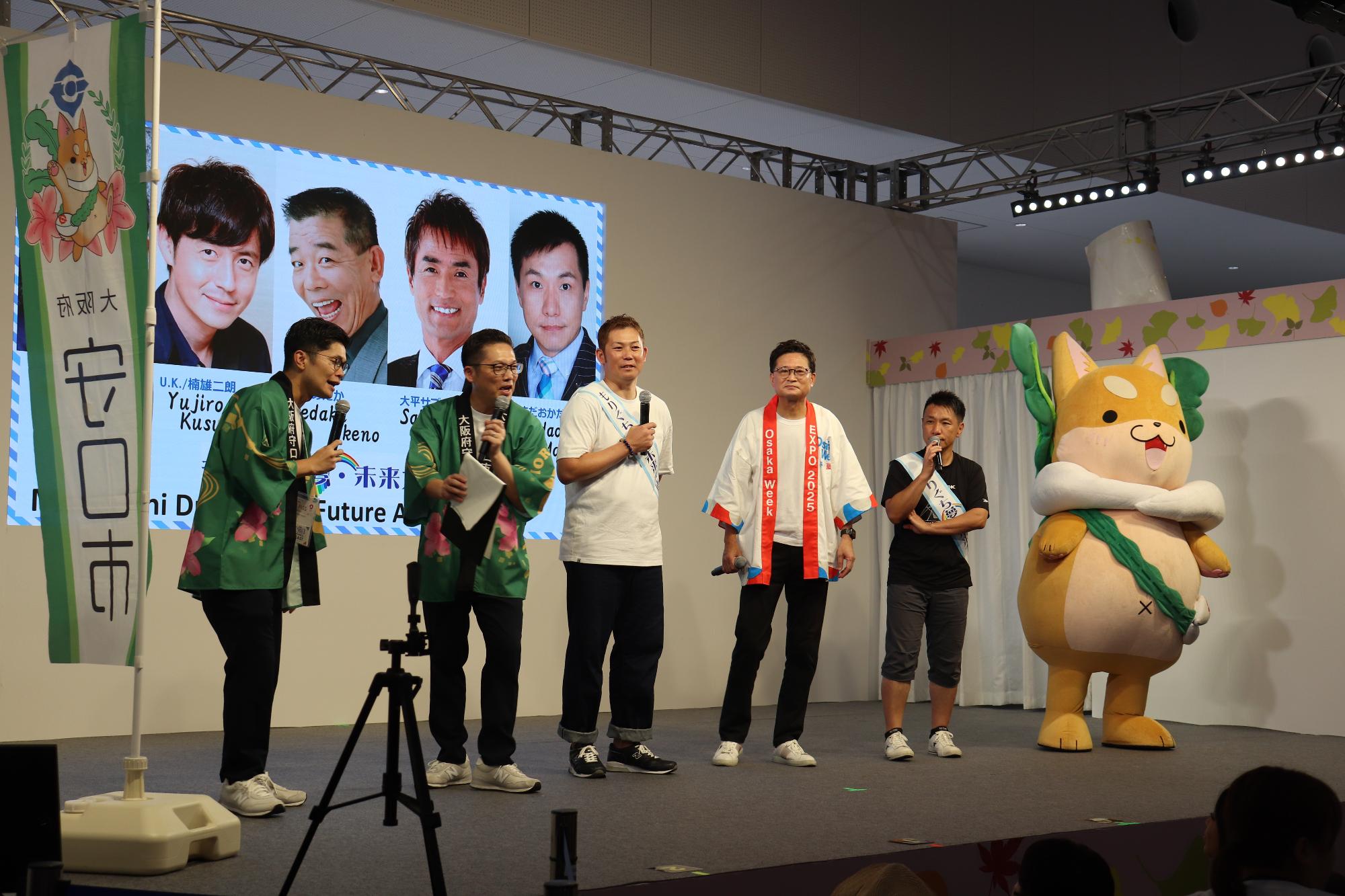 もりぐち夢未来大使と市長ともり吉が舞台に立っています