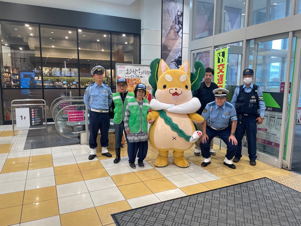 イオン大日入口にて警察官と親子ともり吉が並んでいる