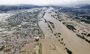 土手が崩壊し河川が氾濫して民家が浸水している様子を上空から写した写真